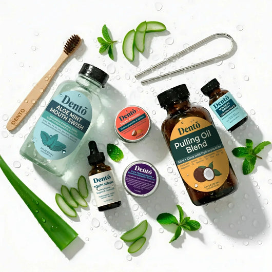 Collection of Dentá skincare and wellness products on a white background with greenery.